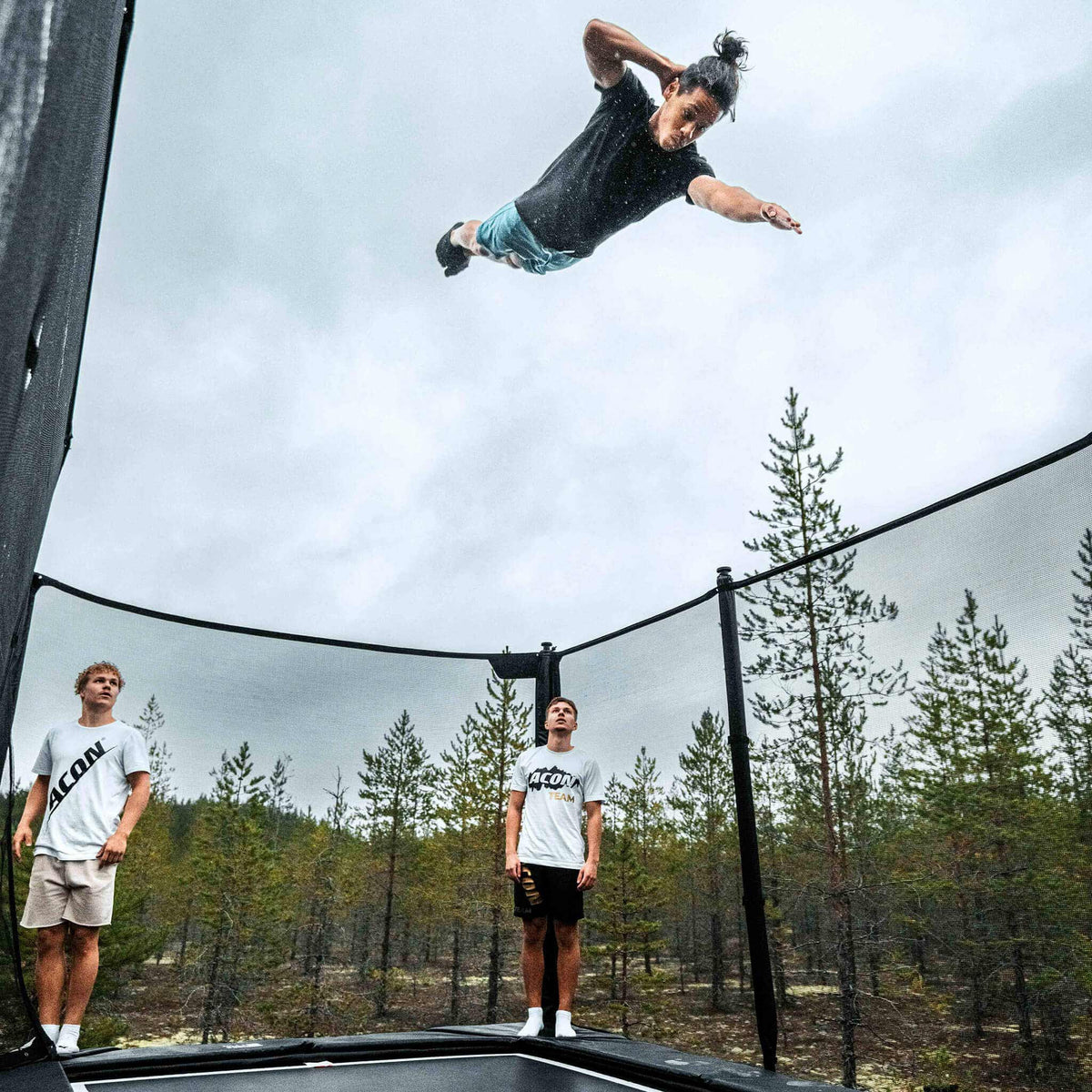 Trampolintricker und seine Kameraden als Publikum auf einem Acon X Trampolin.