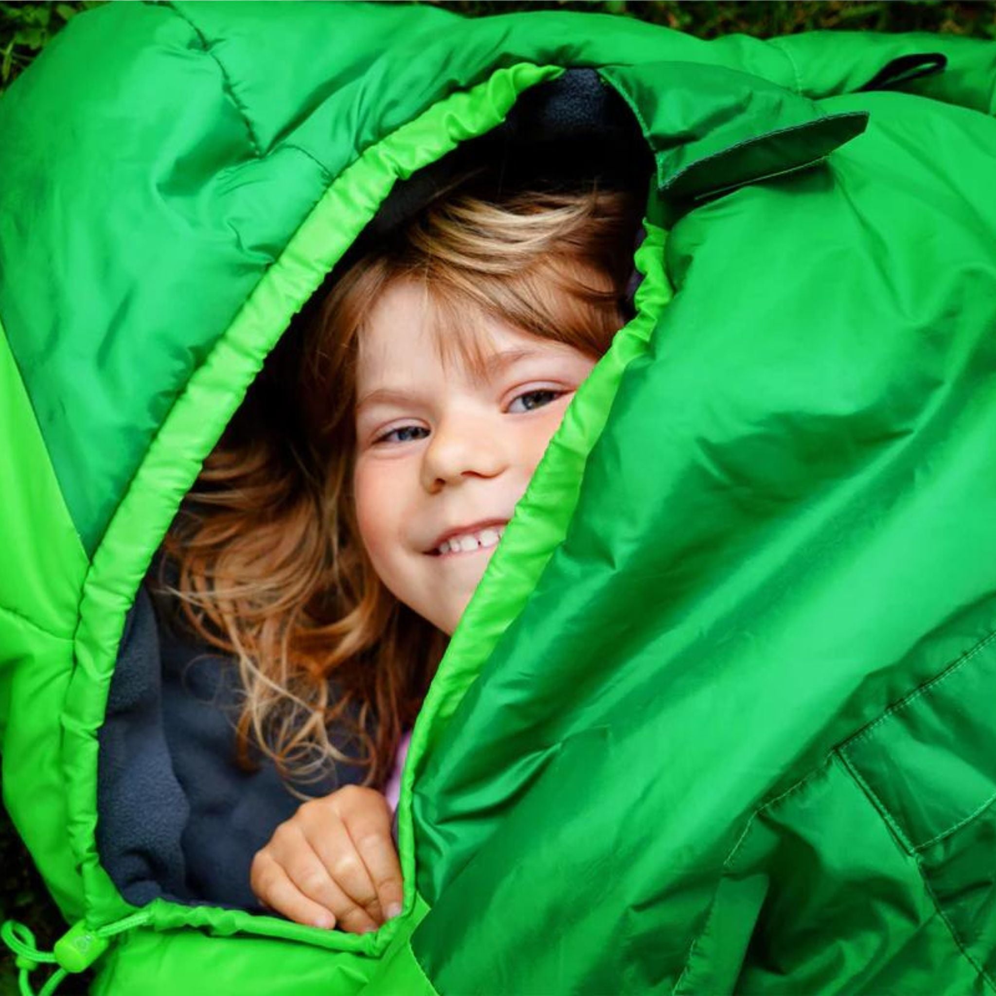 Kind in Schlafsack. Übernachten auf Trampolin.