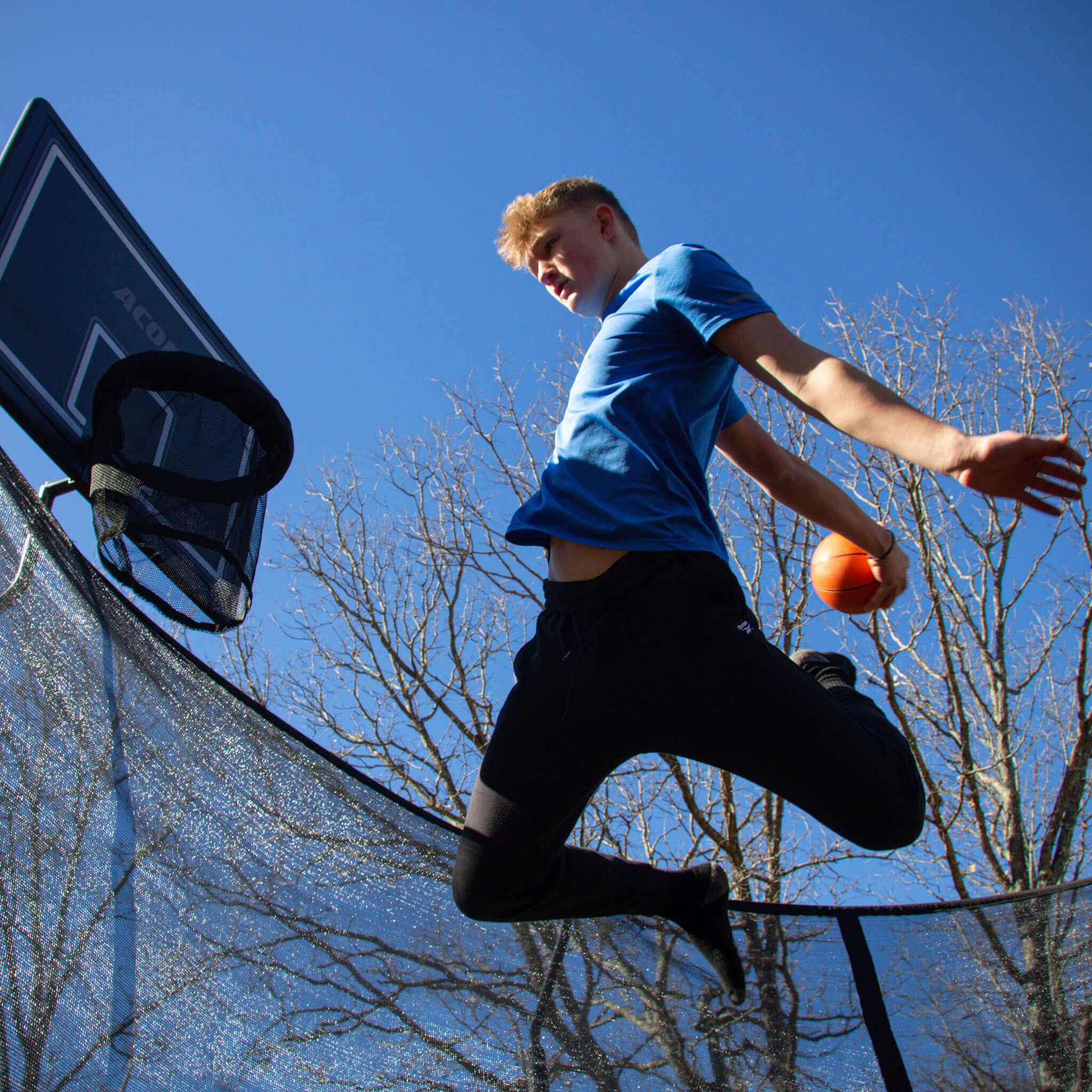 Basketballspieler auf einem runden Trampolin.