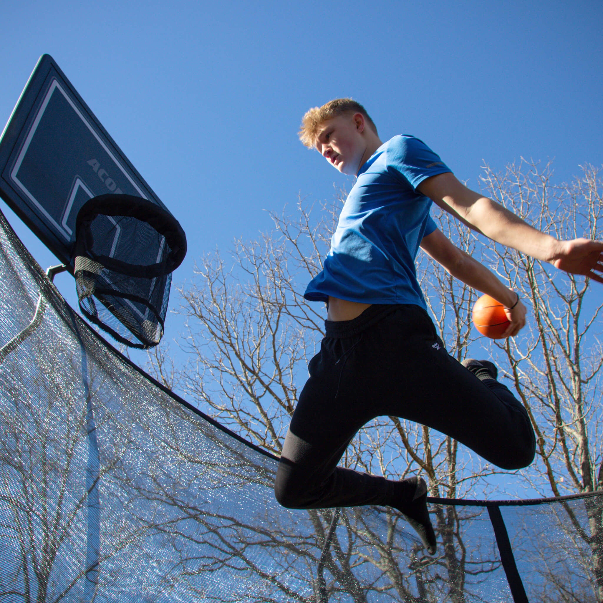 Ein Junge spielt Trampolin-Basketball.